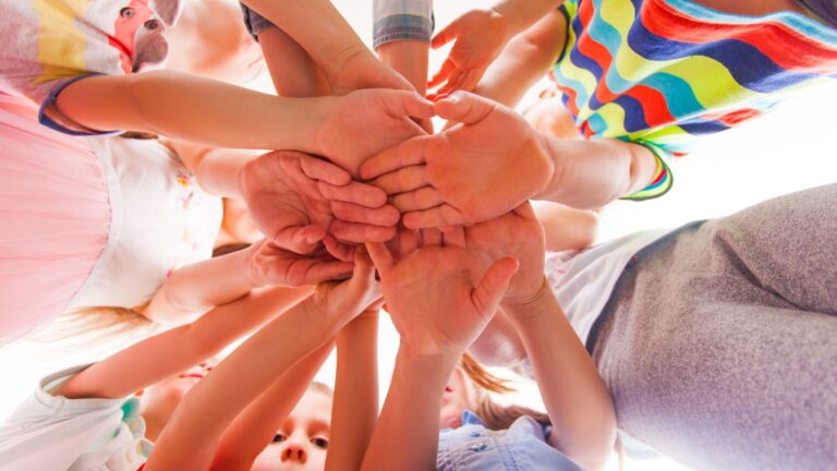 Kids are putting hands together, teamwork and friendship